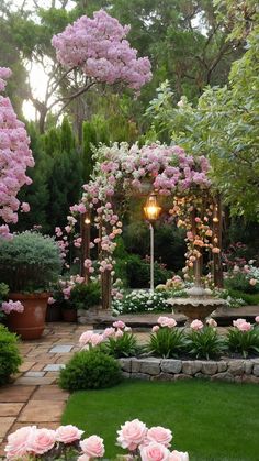 a garden with lots of pink flowers and greenery