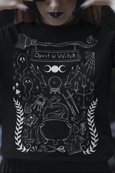 a woman with her hands on her head wearing a black shirt that says spirit and witch