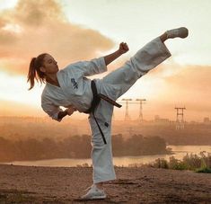 a woman is practicing karate in the sunset