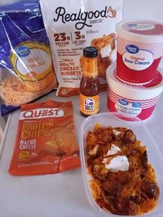 some food is sitting on a table with chips, ice cream, and other items