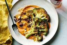 a white plate topped with broccoli covered in sauce