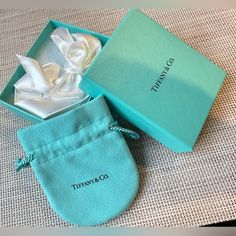 an open tiffany co shoe box on a table with its lid opened and the shoes in it's pouch