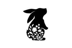 the silhouette of a rabbit with flowers in its ears