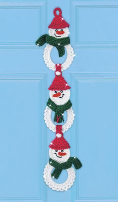 three snowman wreaths hanging on the front door