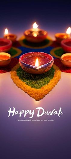 happy diwali greeting card with lit candles on the ground and colorful decorations around it