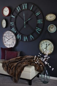 a living room with several clocks on the wall and a fur thrower in front of it