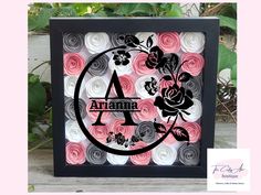 a black frame with pink and white flowers on it