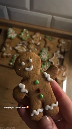 someone is holding up a small gingerbread man