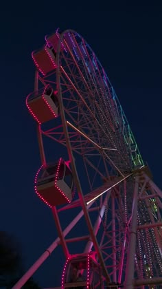 the ferris wheel is lit up at night