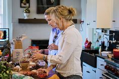 two women are preparing food in the kitchen