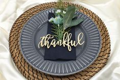 a table setting with a plate, napkin and flower centerpiece that says'grateful '