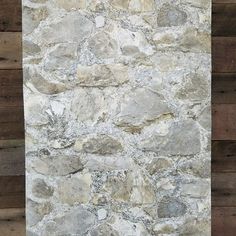 a stone wall with wood planks in the background