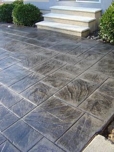 an outdoor patio with steps and bushes