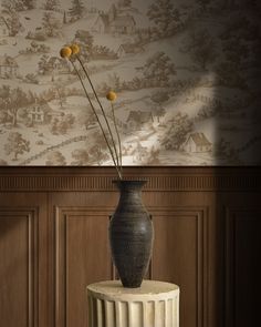 there is a vase with flowers in it on the table next to a wallpaper