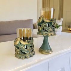 two candle holders sitting on top of a white counter