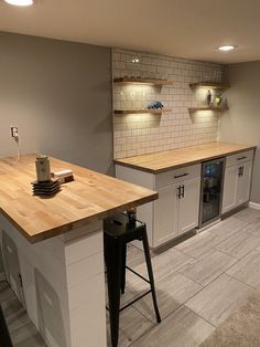 a kitchen with white cabinets and wooden counter tops