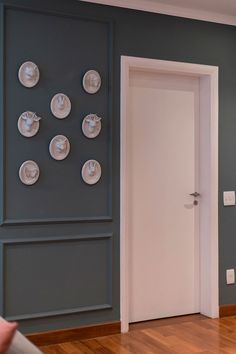 an open door in a room with plates on the wall and wood flooring around it