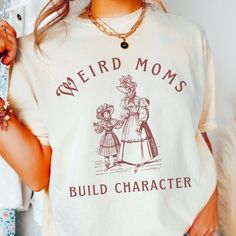 🩴 Weird Moms Build Character Shirt. Humorous Victorian Design T-Shirt. 🩴 Click here to view our shop for more great designs --- https://www.etsy.com/shop/GraceAndFlipFlops Click on the ❤️ to see our new designs as they arrive. 🩴 Comfort Colors T-Shirts - Made with 100% ring-spun cotton. The soft-washed, garment-dyed fabric brings extra coziness to your wardrobe while the Unisex relaxed fit makes it an excellent daily choice. The double-needle stitching throughout the tee makes it highly durab Weird Shirt Design, Weird Moms Build Character, Homeschool Shirts, Build Character, Mama Crewneck, Mom Graphic Tees, Crafty Mom, Funny Mom Shirt