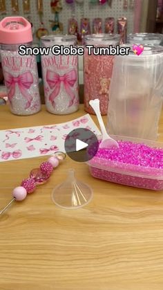 a table topped with lots of pink beads and plastic containers on top of wooden tables