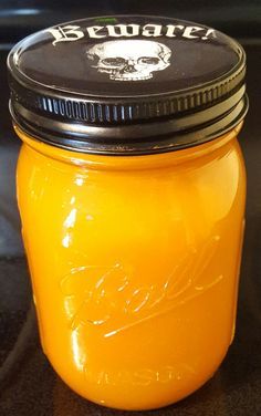 a jar filled with yellow liquid sitting on top of a counter