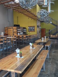 an empty restaurant with wooden tables and benches