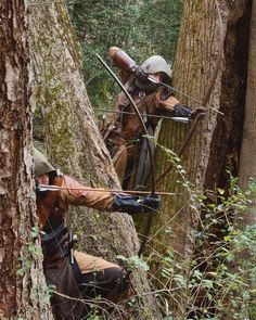 two men in the woods with their backs turned to look like they are aiming at something