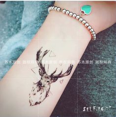 a deer head tattoo on the wrist with beads around it's neck and an arrow