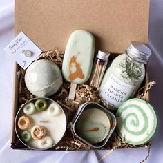 an assortment of soaps in a box on a bed