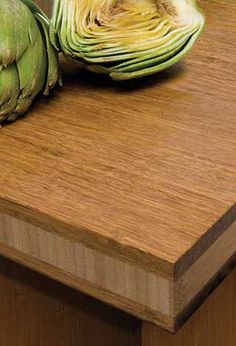 two artichokes sitting on top of a cutting board next to each other