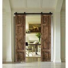 an open door leading to a dining room with white walls and wood trimmings