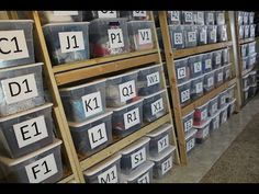 the shelves are full of plastic containers with letters and numbers on them, along with other bins