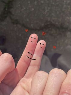 two fingers with smiley faces drawn on them