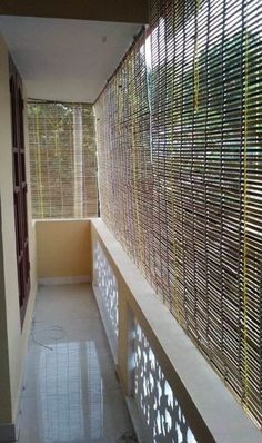 an empty hallway with bamboo blinds on the wall