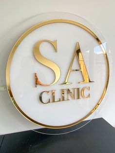 a glass sign that says sa cleing in gold lettering on a white background