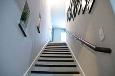 there is a long stair case going up the stairs with black and white striped railings