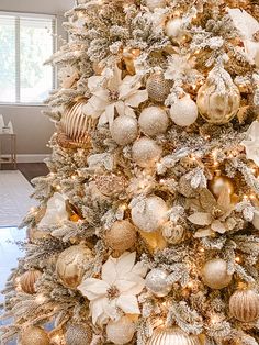 a white christmas tree with gold and silver ornaments