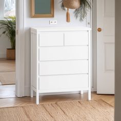 a white dresser sitting next to a doorway