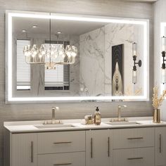 a bathroom vanity with two sinks and a large mirror above it that has lights on the side