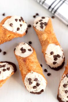 several pastries with chocolate chips and marshmallows in them on a white surface