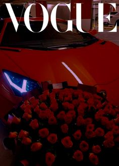 a red sports car parked next to a bunch of roses with the words voquet on it