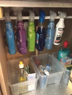 an organized kitchen cabinet filled with cleaning products