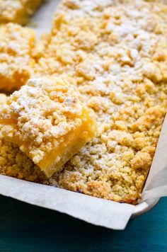 some food that is sitting in a pan on a blue table and it looks like crumbs