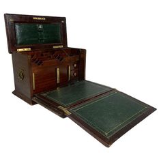 an antique wooden trunk with green leather linings and gold trimming on the doors