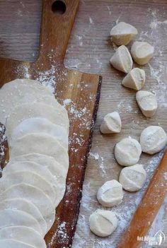 doughnuts are being made on a wooden cutting board