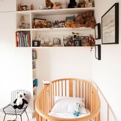 a baby crib with stuffed animals on the shelves