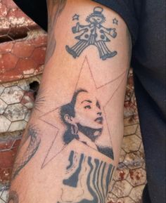 a man with a tattoo on his arm has a star and a woman's face