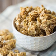 a white bowl filled with granola sitting on top of a blue and white table cloth