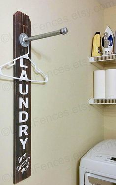 a laundry sign hanging on the wall next to a washer and dryer