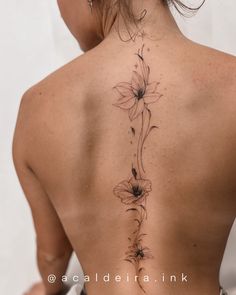 the back of a woman's neck with flowers on it