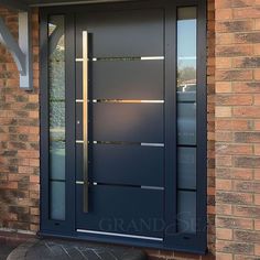 a blue front door on a brick house with glass panels and sidelights, next to a stone step